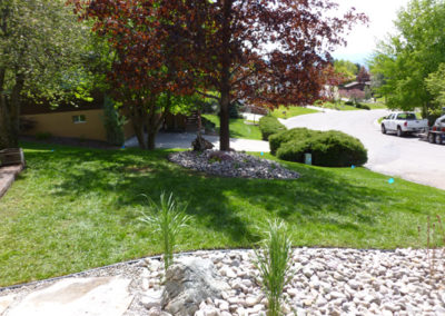 River Rock planting areas on sloped lawn