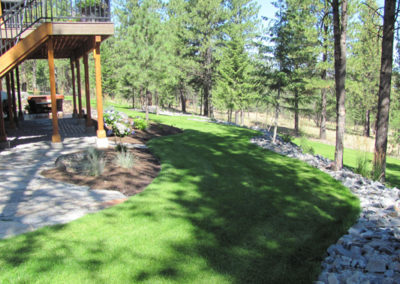 Sloped lawn, planting areas pathway and accent rock